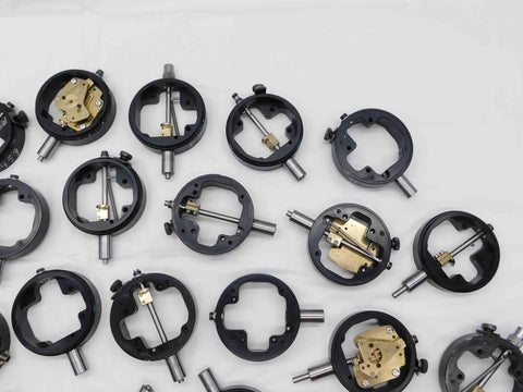 Assorted Dial Test Indicator Spare Parts Bundle Plug And Play For Precision Machine Repair Featuring Rock Solid Replacement Gears Dials And Workbench Hardware Pack. Close-up of precision gauge components, black metal housing with brass fittings.