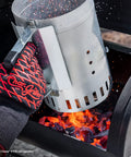 Person using Chimney Style Charcoal Grill Starter with Quick Release Trigger to light coals in a BBQ grill, 12 inch size