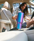 Woman placing Co Pilot Insulated Travel Mug With Straw And Flip Cap Lids 40 Oz Leak Proof Cup Holder Friendly in car, Aurora color.