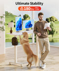 Electric Standing Desk With Adjustable Height And Memory Presets Heavy Duty Steel Base Roller Casters 48X24 Inches white with dog and person.