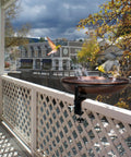 Deck Mounted Metal Bird Bath With Adjustable Steel Clamp For Railings And Balconies, installed on a wooden deck railing with birds using the bowl.