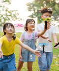 Kids playing with Awesome Flying Saucer Toy Set With 32 Discs And 16 String Launchers in a park