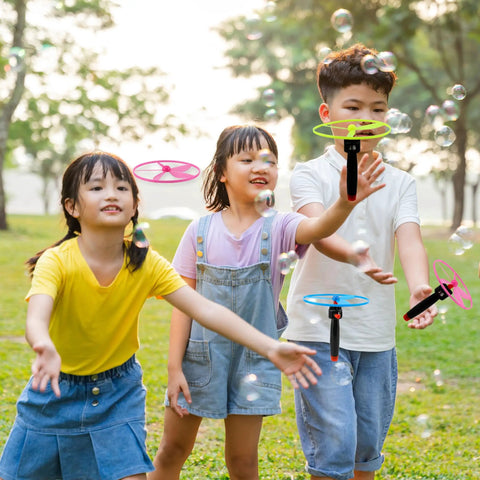 Kids playing with Awesome Flying Saucer Toy Set With 32 Discs And 16 String Launchers in a park