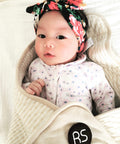 Baby wrapped in Ultra Soft Organic Cotton Baby Blanket With EMF Shielding For 5G, cream color, cozy and safe for infants.
