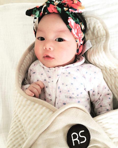 Baby wrapped in Ultra Soft Organic Cotton Baby Blanket With EMF Shielding For 5G, cream color, cozy and safe for infants.