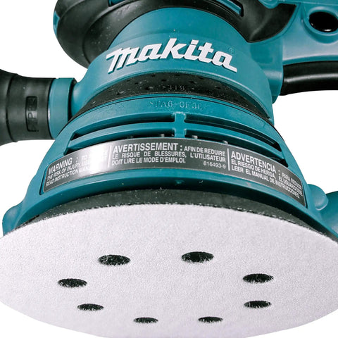 Close-up of five-inch random orbit sander with 8-hole sanding disc attached, part of the Multi Grit 30 Piece Five Inch Random Orbit Sanding Disc Set With Eight Hole Hook And Loop Includes 10 Of Each 80 120 240 Grit Discs For Wood Metal Drywall And More A DIY Ready Must Have For Heavy Material Removal And Smooth Finishes.