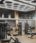 Hexagon LED Garage Lights Honeycomb Grid Panels 672W 80640LM 6500K in gym with equipment, rectangular frame view