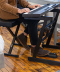 Heavy Duty Folding Z Keyboard Stand With Adjustable Height From 23.5 To 36.5 Inches in use with keyboard and musician