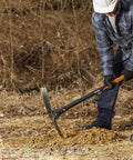 Person using IsoCore Garden Pick Pro 5 Pound With 36 Inch Shock Controlled Handle for tough soil, orange and black design