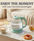 Elite Gourmet Mint Glass Electric Kettle 1L BPA-Free Fast Boil cordless with auto shut off on a marble table.