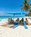 10x10 Ft Beach Sun Shelter Tent With Lycra Canopy Adjustable 2 Or 4 Pole Setup on a beach providing shade for a group.