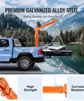 Electric Pickup Truck Crane With 6000 Lb Winch 12V Bed Mounted Folding Jib Hoist Steel Construction 360 Degree Swivel Built To Haul Heavy Lifting For Construction And Factory Jobs mounted on a blue truck lifting a small boat by a lake.