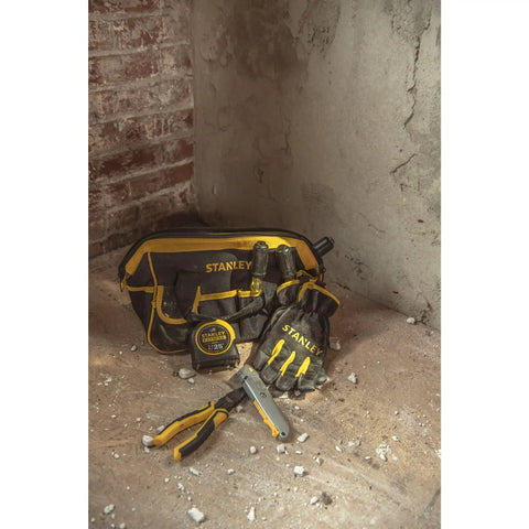 FatMax 25 Foot Magnetic Tape Measure With 11 Foot Standout Armor Blade Coating beside tool bag and gloves on concrete floor