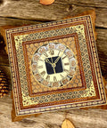 Decorative wooden wall clock with intricate design, featuring Roman numerals, surrounded by autumn leaves and pinecones.