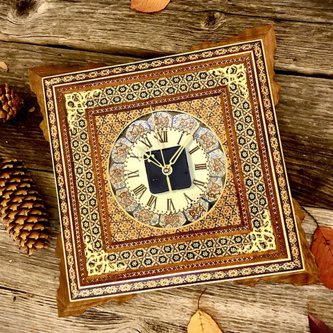 Decorative wooden wall clock with intricate design, featuring Roman numerals, surrounded by autumn leaves and pinecones.