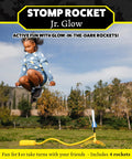 Child jumping to launch Glow In The Dark Rocket Launcher Kit for Kids with Four Soft Foam Rockets, outdoor fun in a park.