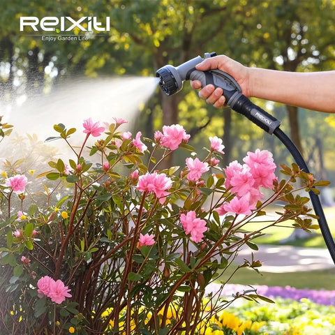 Relxitl garden hose with 10-function spray nozzle, black flexible hose watering pink azalea bushes.