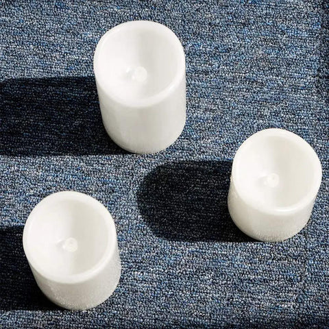 Top view of Set Of 6 Flameless LED Candles With Realistic Flicker, Battery Powered 6 Inch Tall By 3 Inch Diameter on a blue surface