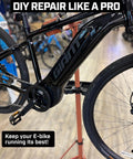 Heavy Duty E Bike Repair Stand With Telescoping Arm holding a black e-bike in a workshop setting