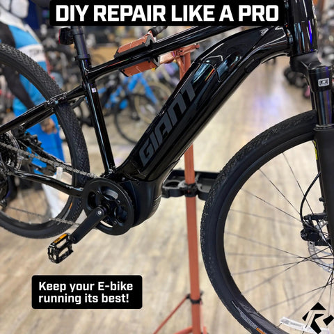Heavy Duty E Bike Repair Stand With Telescoping Arm holding a black e-bike in a workshop setting
