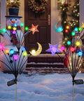 Colorful decorative garden lights with stars and moons in snow, front yard with snowman; focus on whimsical festive lighting.