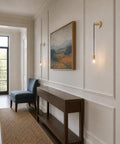 XYDikssn Crystal Wall Sconces, Brushed Gold Brass Wall Lights with Clear Crystal Glass above a console table in a hallway.