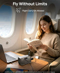 Slick Pocket Sized Portable Power Station With Resilient LiFePO4 Cell And 100 Watt Output on an airplane table, being used while reading.