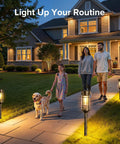 Family walking at night on a lit pathway with 4 Pack Solar Firefly Lights Outdoor Garden Decor with 32 LED Swaying Iron Wire Bulbs