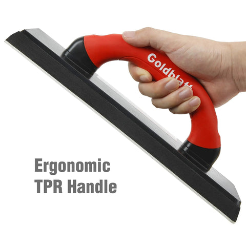 Close-up of a hand holding a 4 Inch By 12 Inch Grout Float For Tile with molded rubber pad and ergonomic soft grip handle.