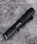 Ultra Bright Mini LED Pen Light Pocket Size Flashlight on wet surface showing water resistance