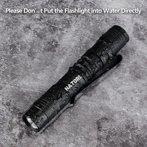 Ultra Bright Mini LED Pen Light Pocket Size Flashlight on wet surface showing water resistance