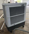 Built Tough Shop Grade Evaporative Air Cooler With Three Speed Fan Blades And Roll Away Casters For Garage Warehouse Cooling Massive 160 Liter Water Tank Swamp Chiller Unit in gray with vents.