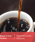 Coffee pouring into a white cup showcasing Sneak-A-Cup feature, enjoy first cup before brewing ends.