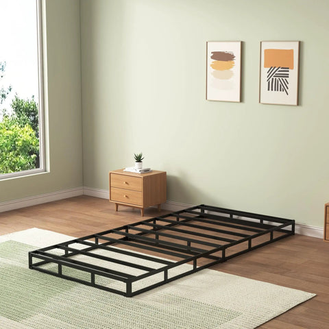 Twin Box Spring Low Profile Heavy Duty Platform Mattress Foundation in black, placed on a rug in a modern bedroom.
