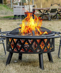 36 Inch Wood Burning Fire Pit with Spark Screen and Fire Poker for Outdoor Hangouts in the Yard Patio and Garden Durable Steel Cross Weave Design Built for Bonfires, with flames burning, chairs around it.