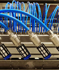 Four Two Pack Plastic Pneumatic Air Mufflers G One Quarter Inch Thread Exhaust Fittings connected in a row with blue hoses.