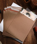 7x9 Inch Rigid Kraft Mailers Self Adhesive Flat Shipping Bags 200 Pack Bulk for office mailing on wooden desk