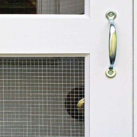 Close-up of a door with 24 Inch By 50 Feet 23 Gauge Galvanized Hardware Cloth With Quarter Inch Openings and metal handle.