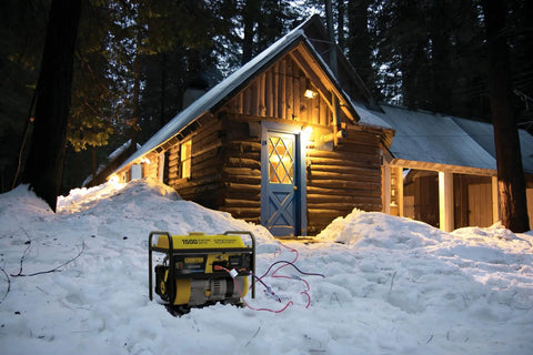 Portable 1500 Watt Generator With 120V 20A Outlet in snow near cabin, lights on, providing reliable outdoor power