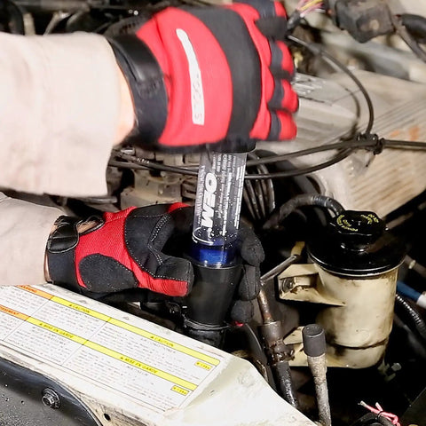 Mechanic using Combustion Leak Detector For Engine Block Leaks And Blown Head Gasket Tests Plastic And Rubber Test Kit in engine bay