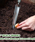 Pro Grade Seeding Widger With 6 Inch Scale, Stainless Steel Planting Trowel used for planting in garden soil.