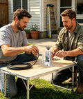 Two men using Heavy Duty Drill Powered Wire Stripper Machine With Manual Hand Crank Option For Efficient Copper Recovery And Scrap Cable Processing Small Portable Peeler Tool on a table.