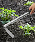 Using a hoe from the Complete 5 Piece Garden Tool Set With Hoe And Cultivator Hand Tiller on soil beside plants in a garden