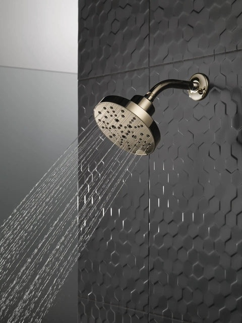 H2Okinetic 5 Setting Raincan Shower Head in Champagne Bronze with Touch Clean spray holes installed on a textured black tile wall