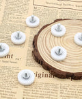 Pack Of Twelve 1 Inch Drawer Slide Roller Wheels Slick Gliding Pom Nylon Construction With Stainless Steel Threads on wood background.