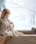 Heavy Duty Door Draft Stopper To Keep The Chill Outta Your Space by a child sitting on a window ledge with stuffed animals.