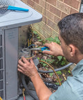 Technician using Workhorse 4 Piece Pliers Set on air conditioning unit outdoors, demonstrating use for tough jobs.