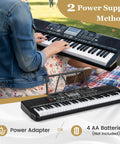 Person playing 61 Key Portable Keyboard Piano With Stand And Bench Lighted Keys 200 Rhythms And 200 Tones outdoors