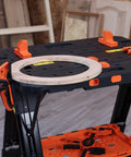4 Pack Clamp Dogs Kit For Portable Folding Work Table on black table with orange clamps and wooden ring, shop background
