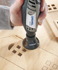 Person using a rotary tool with Multipurpose Cutting Bit for Rotary Tools One Eighth Inch Spiral Flute Ideal for Cutting Wood Plastic Fiberglass Drywall Laminate Aluminum and Vinyl Siding Ready To Use With Attachments And Pro Grade Cutting Performance on wood.